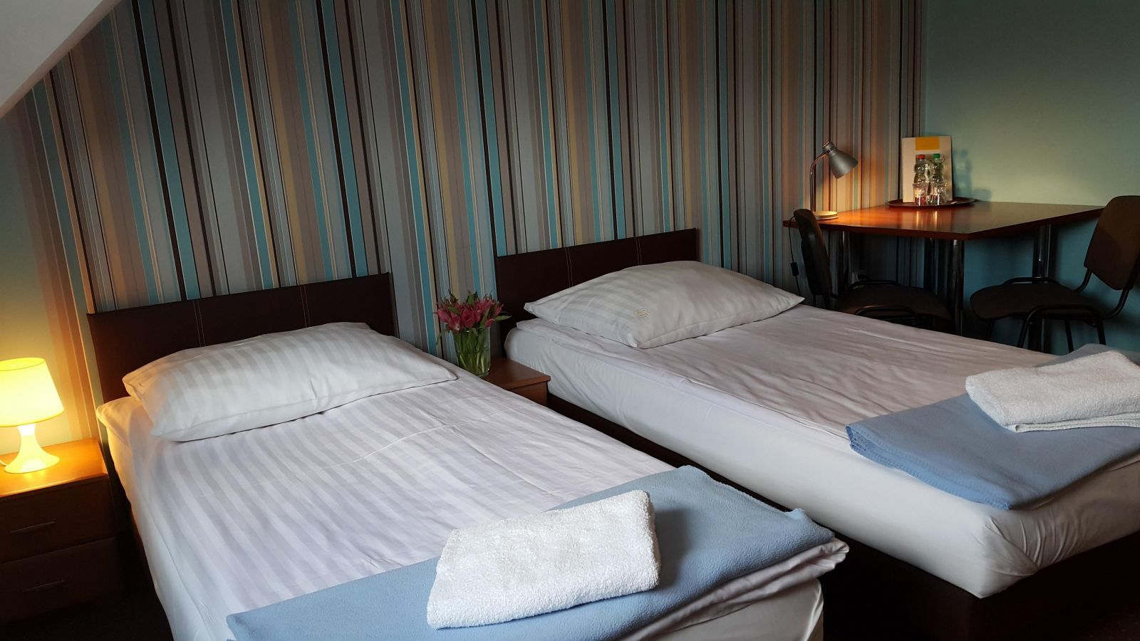 Route One - Restauracja & Pokoje Hotelowe in Zgierz: twin beds in a simple guest room with desk and lamp