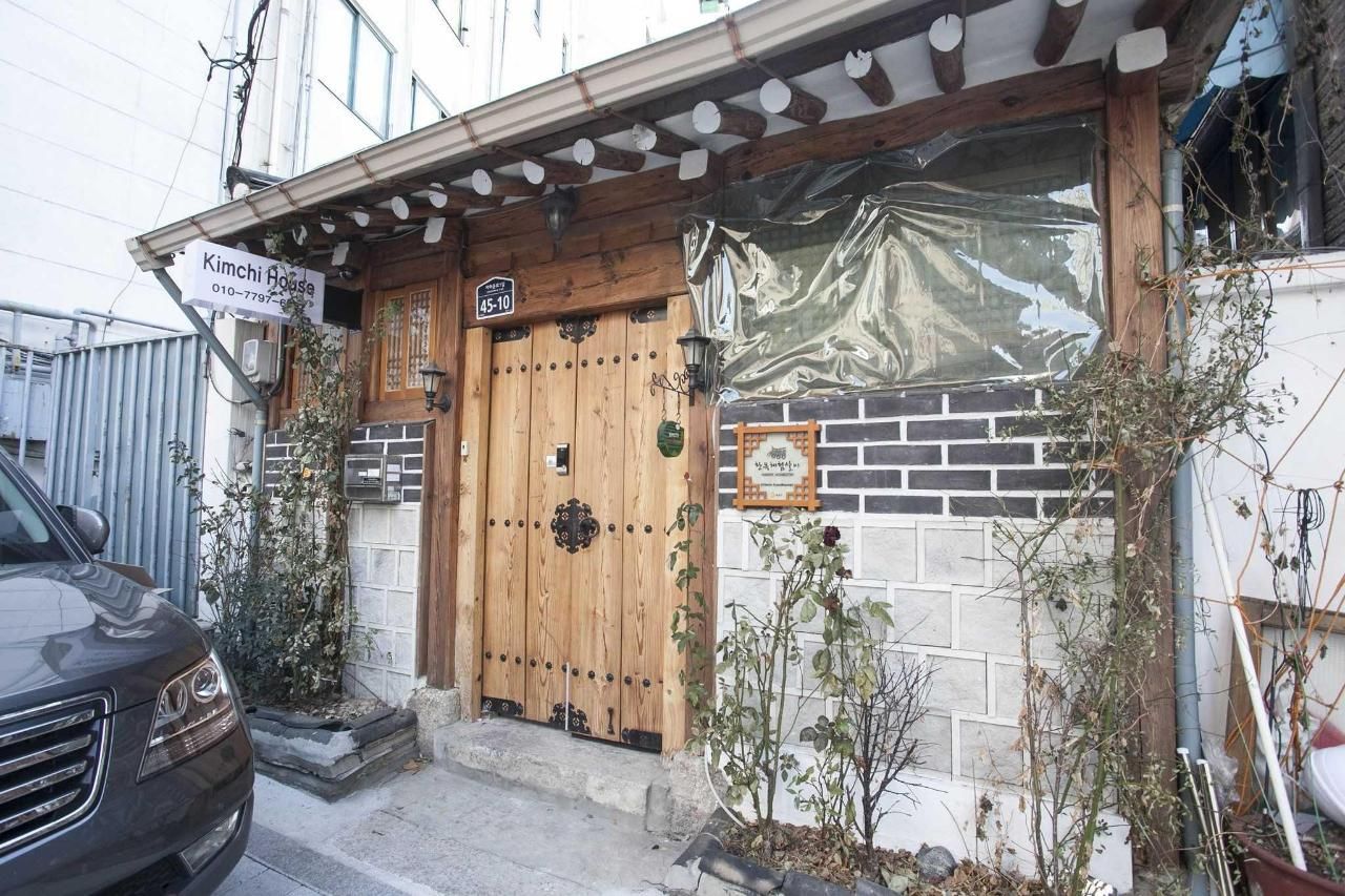 Kimchi Guest House in Seoul exterior with rustic wooden entrance and brick facade