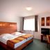 Hotel Kaiser in Berlin guest room with twin beds, desk, TV, and large window