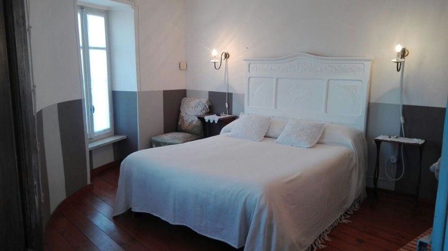 Dimora San Sebastiano in Neive, bedroom with white bed, wall sconces and window seat