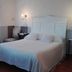 Dimora San Sebastiano in Neive, bedroom with white bed, wall sconces and window seat