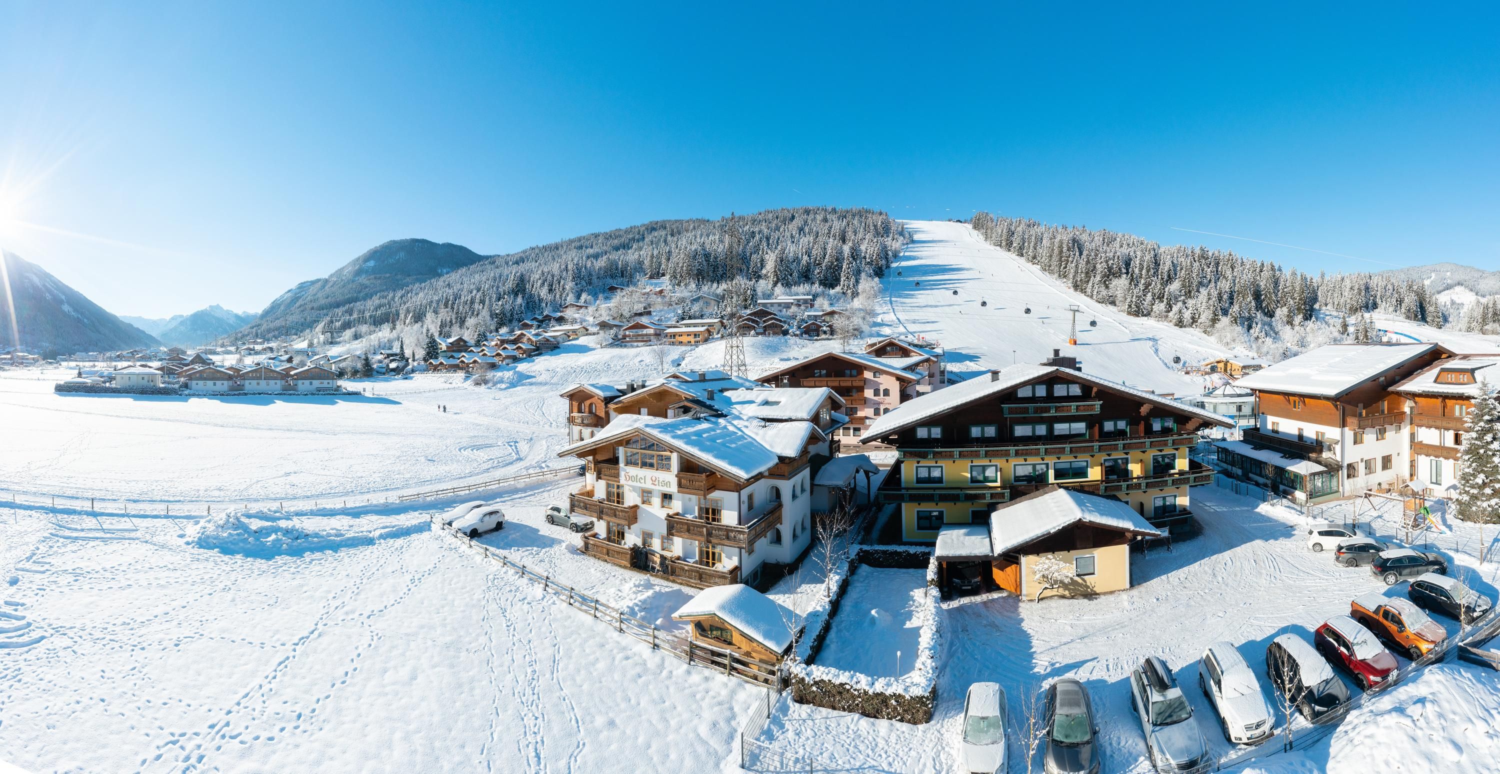 B&B Hotel Die Bergquelle in Flachau, snowy alpine hotel village beside ski slopes and mountains