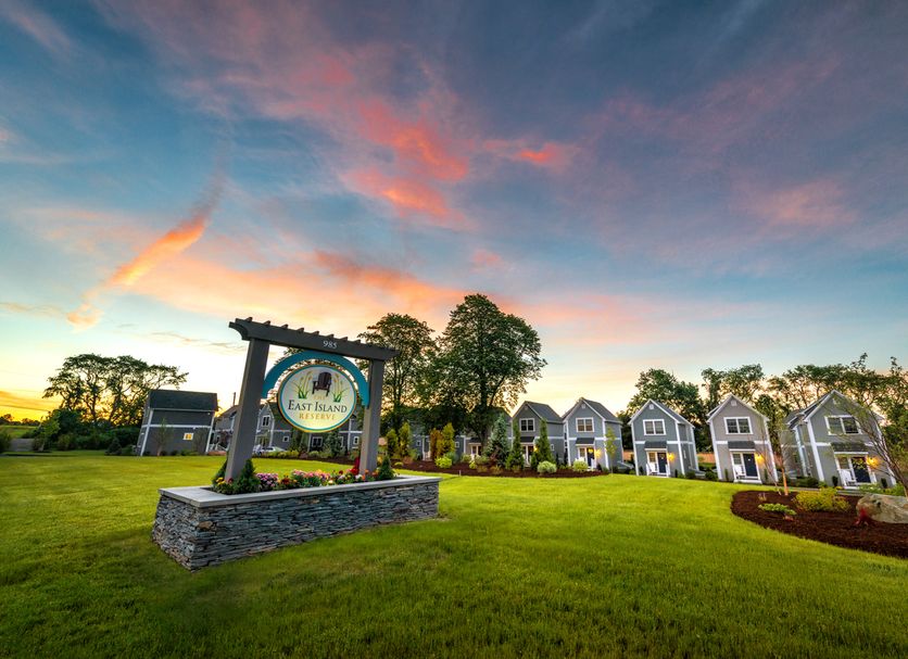 The East Island Reserve Hotel in Middletown with landscaped lawn and row of cottages at sunset