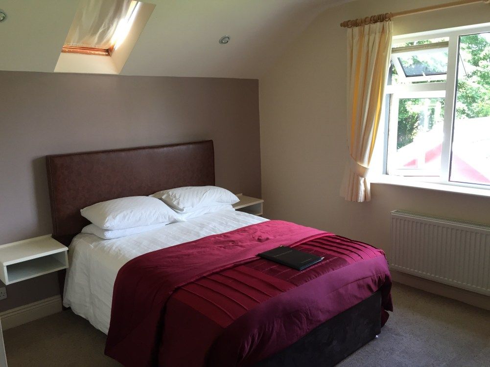 Muckross Drive House in Killarney bedroom with double bed, skylight and window with curtains