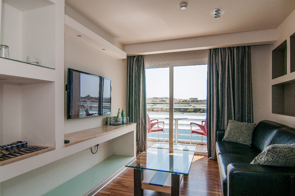 Pebbles Boutique Aparthotel in Sliema living room with balcony sea view and glass coffee table