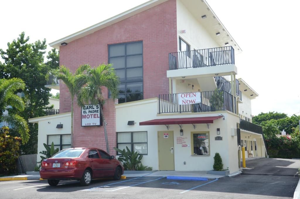 Carl's El Padre Motel in Miami exterior with balconies, palm trees, and parked red car