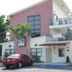 Carl's El Padre Motel in Miami exterior with balconies, palm trees, and parked red car
