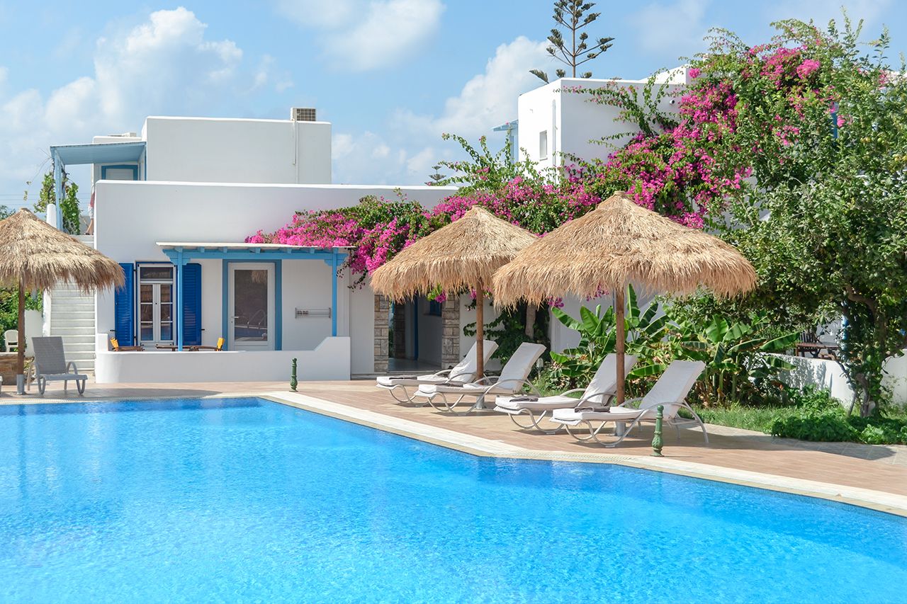 Aggeliki's Diamond in Agia Anna with a pool, sun loungers, and straw umbrellas beside white villas