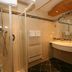 Alpenhotel Neuwirt in Schladming bathroom with shower, towel radiator and curved vanity sink