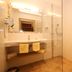 Alpenhotel Neuwirt in Schladming bathroom with double sink vanity and glass shower