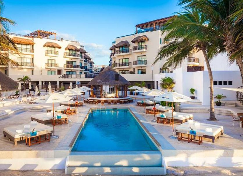Tukan Hotel & Beach Club in Playa del Carmen, courtyard pool with loungers and palm trees