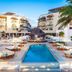 Tukan Hotel & Beach Club in Playa del Carmen, courtyard pool with loungers and palm trees