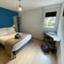 Hôtel Azur in Agde guest room with double bed, desk by window, and blue accent wall
