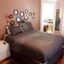 The Mansion Inn in St. Petersburg guest room with bed, mirrored wall accents, and hardwood floors