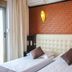 Hotel Liro - Adults Only in Vlorë: twin bed room with brick accent wall and balcony door