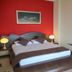 Hotel Liro - Adults Only room in Vlorë with red accent wall, double bed, bedside lamps and wall art