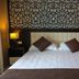 Hotel Liro - Adults Only in Vlorë guest room with king bed, bedside lamps, and patterned wall panel