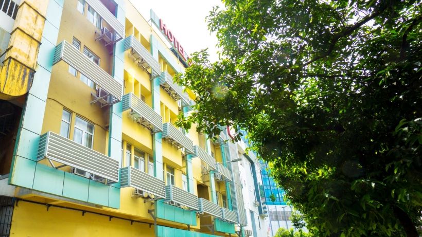 Zen Rooms Near Asia City hotel in Kota Kinabalu with colorful facade beside lush trees
