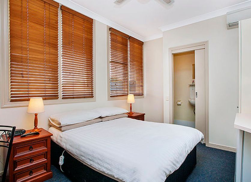 Ashfield Manor, Sydney guest room with double bed, bedside lamps, and wooden blinds