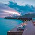 Heritance Aarah in Meedhoo: overwater deck with lounge chairs beside turquoise sea at sunset