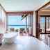 Heritance Aarah in Meedhoo bathroom opens to a beachfront deck with ocean views and lounge chairs.