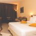 Hotel Des Roches in Kourou: guest room with bed, sofa, desk, and balcony doors