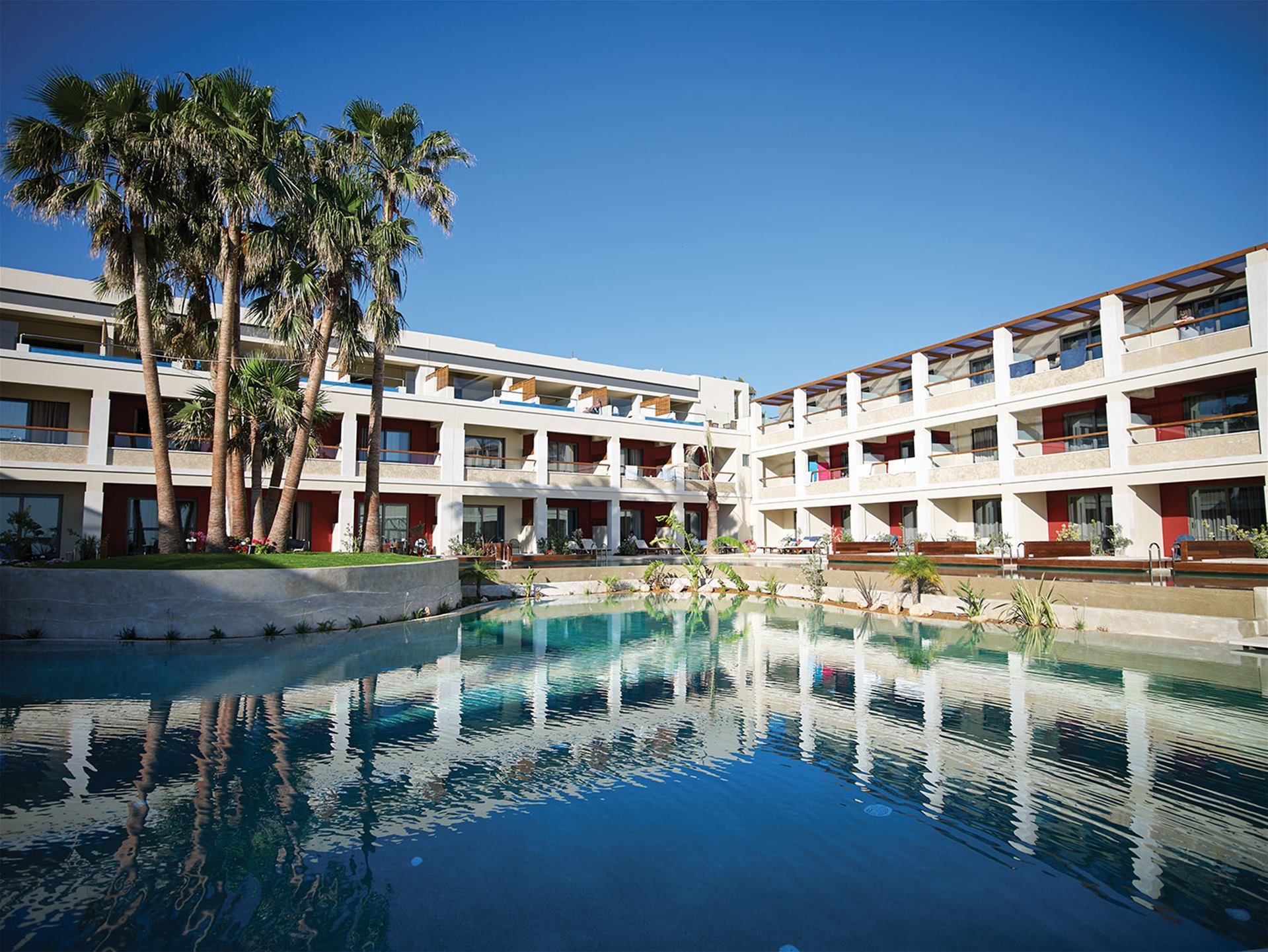 Atlantica Kalliston Resort - Adults Only in Chania with a large outdoor pool and palm trees