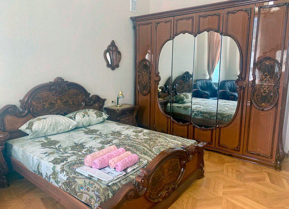 Kharkovlux in Kharkiv bedroom with ornate carved wooden bed and mirrored wardrobe