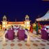 Umaid Mahal Jaipur rooftop terrace with purple chairs, white canopies and palace-style towers at dusk