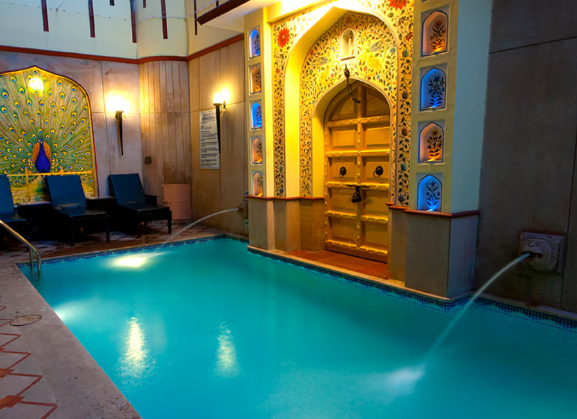 Umaid Mahal, Jaipur indoor pool with ornate Rajasthani archway and lounge chairs