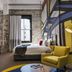 Hotel Woolstore 1888, Sydney guest room with bold mural wall, yellow chair and window light