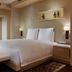 Park Hyatt Beijing guest room with king bed, bench, city-view windows and bedside lamps in Beijing