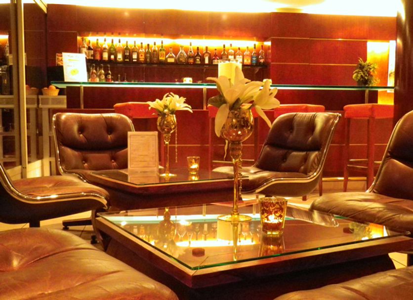 Hôtel Le Yachtman, La Rochelle lounge with leather chairs, glass coffee tables and a backlit bar