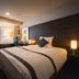 Air Terminal Hotel in Chitose guest room with king bed, desk, TV, lamp, and window seating