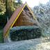 Pousada Passaredo in Gonçalves: A-frame cabin with steep roof, trees and frosty yard