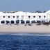 Solymar in Isla Cristina beachfront hotel viewed across sand and sea with white facade and oceanfront arcades