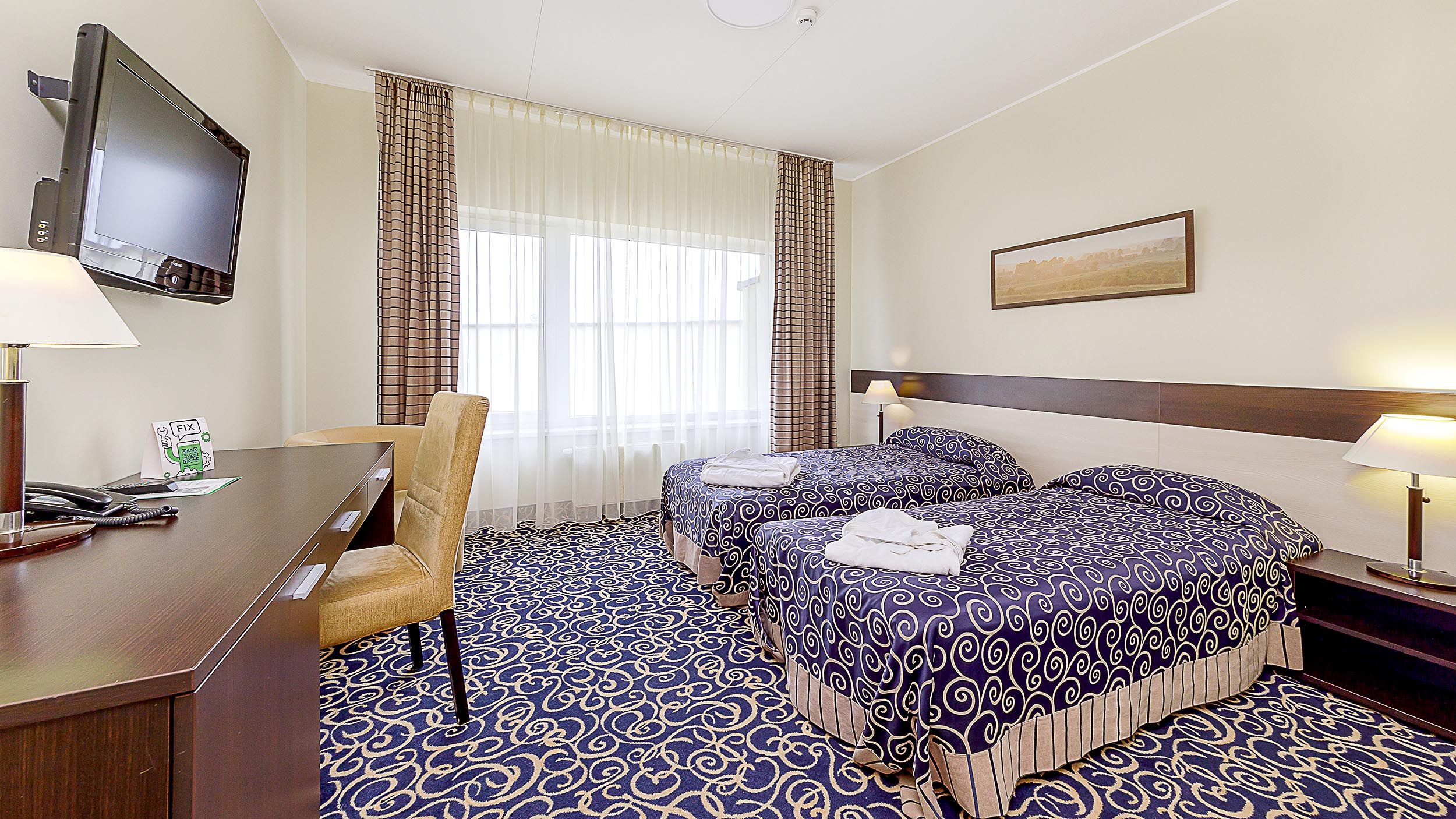 Medical Spa Egles Sanatorija guest room in Druskininkai with two twin beds, desk, TV, and large window