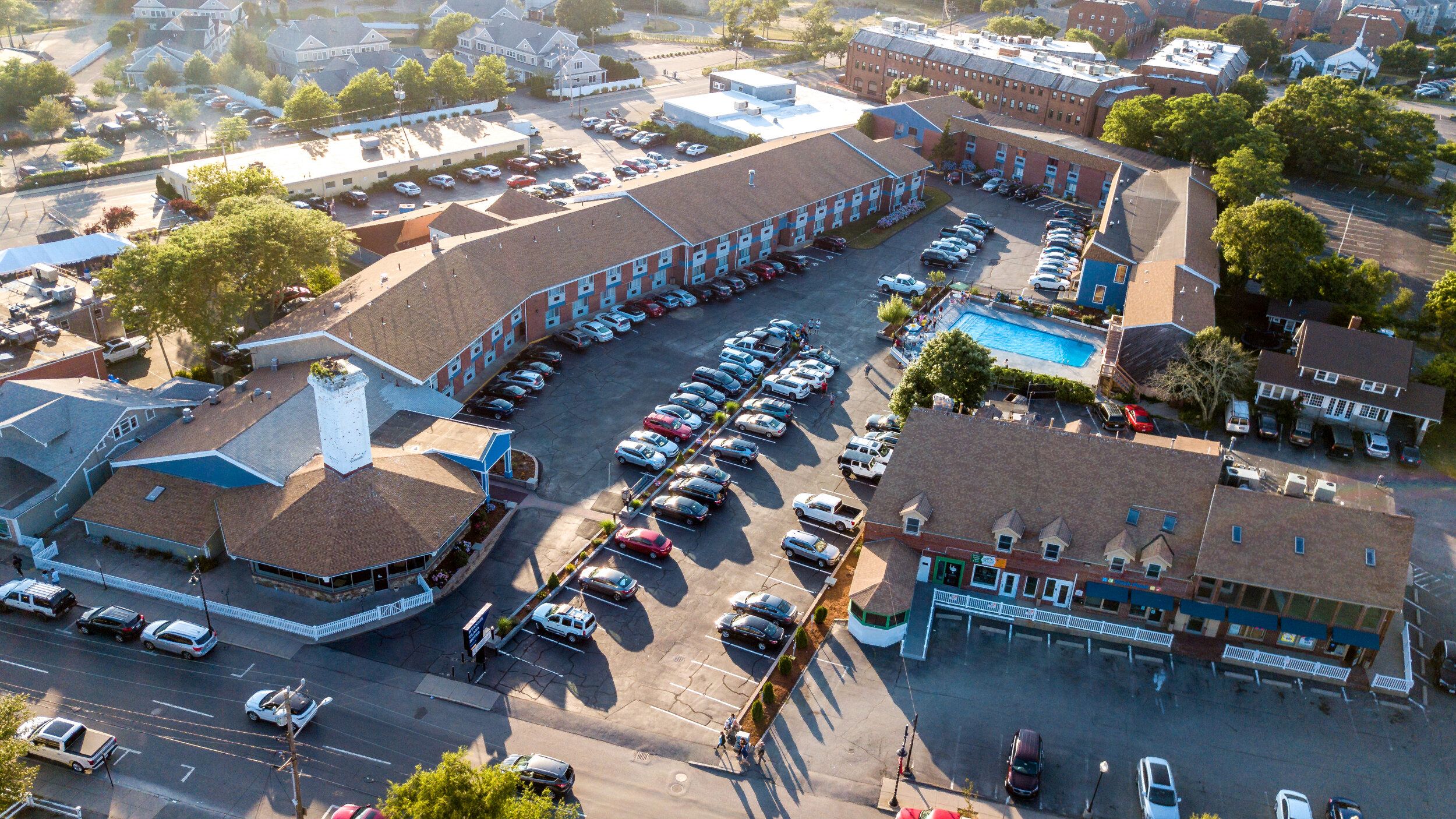 Aerial view of Hyannis Plaza Hotel in Hyannis with parking lot, buildings, and surrounding streets