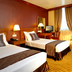 Oxford Hotel Singapore guest room with two single beds, desk, TV, and floor-to-ceiling curtains