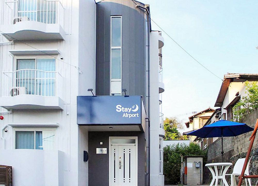 Stay Airport in Fukuoka exterior with balconies and a blue patio umbrella